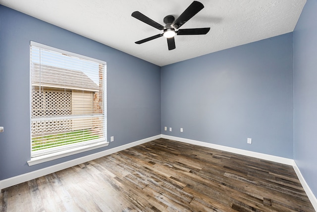 unfurnished room with baseboards, ceiling fan, and dark wood finished floors