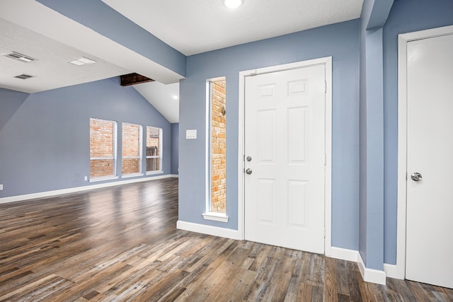 entryway featuring baseboards, vaulted ceiling with beams, wood finished floors, and visible vents