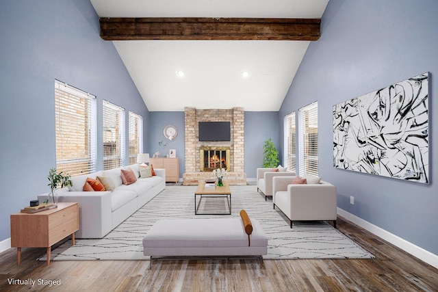 living room with beam ceiling, a healthy amount of sunlight, and high vaulted ceiling