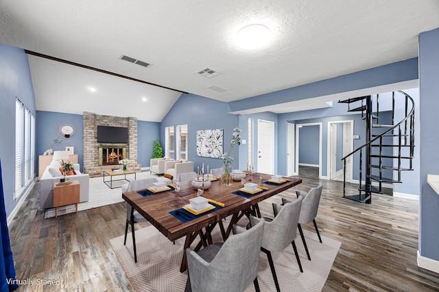 dining area featuring visible vents, baseboards, lofted ceiling, and wood finished floors