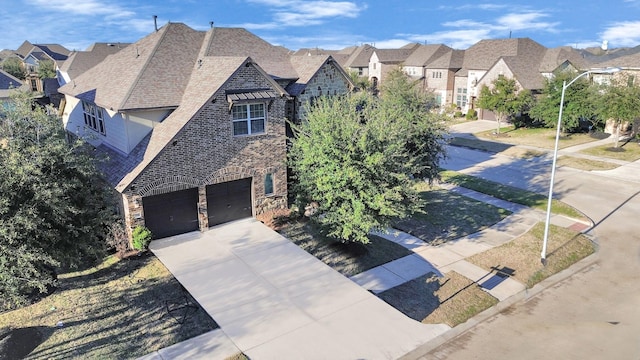 view of front of house with a garage, stone siding, roof with shingles, concrete driveway, and a residential view