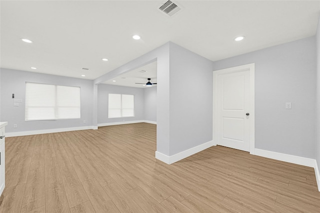 unfurnished room with baseboards, a ceiling fan, light wood-style flooring, and visible vents
