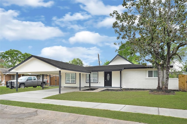 ranch-style home featuring brick siding, a front lawn, fence, and a carport