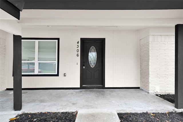 view of exterior entry with brick siding