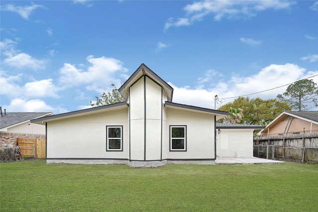 rear view of property with fence, a patio, and a yard