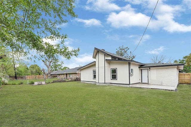rear view of house with a patio, fence, and a yard