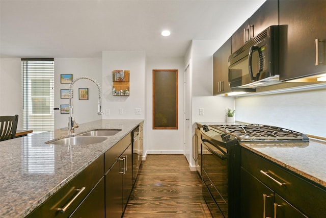 kitchen with light stone countertops, a sink, baseboards, dark wood-style floors, and black appliances