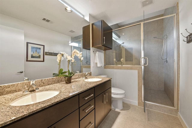 full bathroom with double vanity, visible vents, a shower stall, and a sink