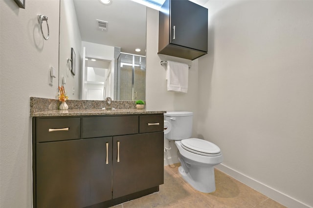 bathroom with visible vents, vanity, a shower with door, toilet, and baseboards