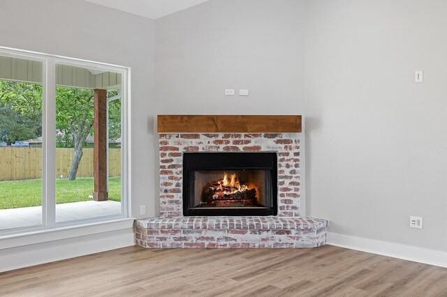 102 Tekla St, Weimar, TX 78962 - details with baseboards, a brick fireplace, and wood finished floors