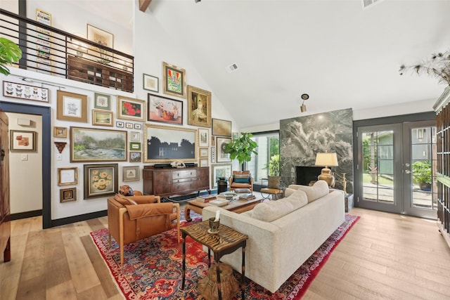 living room featuring french doors, visible vents, light wood-type flooring, high vaulted ceiling, and baseboards