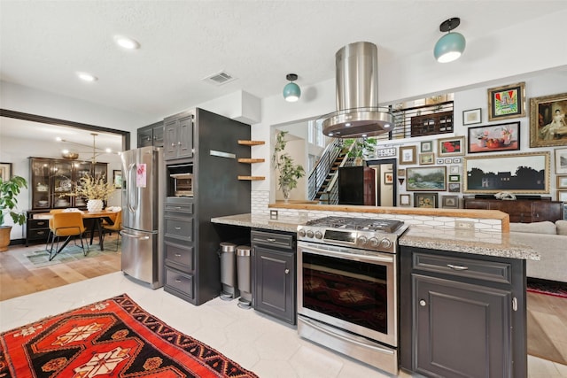 kitchen featuring visible vents, open shelves, a peninsula, open floor plan, and appliances with stainless steel finishes