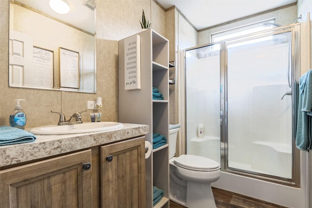 620 Lagoon Dr, Point Blank, TX 77364 - bathroom featuring visible vents, a stall shower, wood finished floors, vanity, and toilet