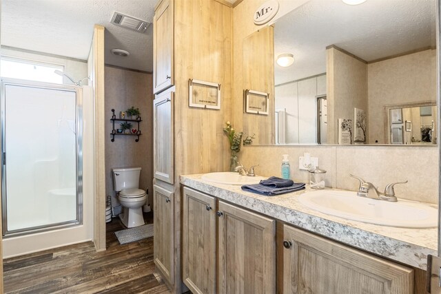 620 Lagoon Dr, Point Blank, TX 77364 - full bathroom featuring a textured ceiling, visible vents, a stall shower, wood finished floors, and a sink
