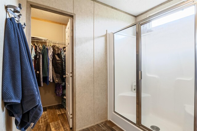 620 Lagoon Dr, Point Blank, TX 77364 - full bathroom featuring a walk in closet, a shower stall, and wood finished floors