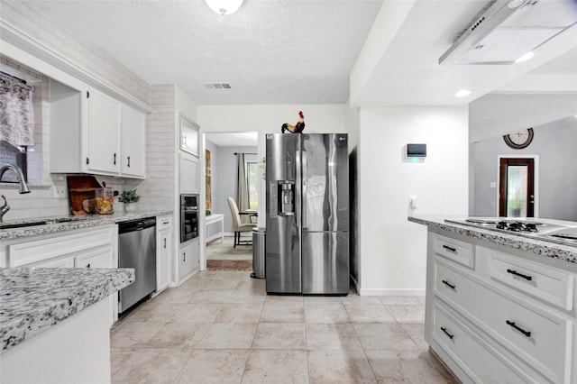 21426 Park York Dr, Katy, TX 77450 - kitchen featuring visible vents, a sink, baseboards, stainless steel appliances, and white cabinetry
