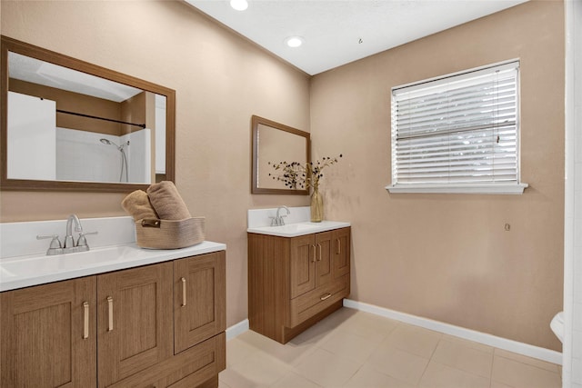 21426 Park York Dr, Katy, TX 77450 - bathroom featuring baseboards, walk in shower, two vanities, and a sink