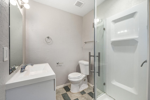full bath with visible vents, a stall shower, vanity, baseboards, and toilet