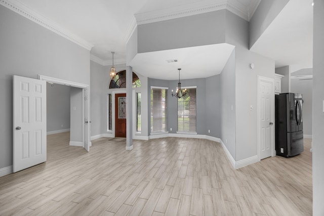 6542 Shinnecock Hills Dr, Houston, TX 77069 - unfurnished living room featuring a chandelier, baseboards, light wood-type flooring, ornamental molding, and a towering ceiling
