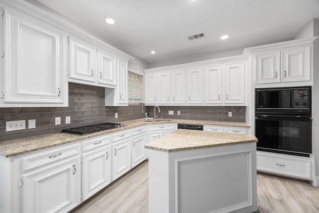 6542 Shinnecock Hills Dr, Houston, TX 77069 - kitchen featuring black appliances, a sink, white cabinetry, light wood-style flooring, and recessed lighting