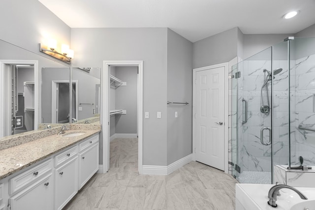 6542 Shinnecock Hills Dr, Houston, TX 77069 - bathroom with a walk in closet, a marble finish shower, baseboards, and vanity