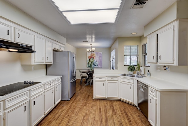 kitchen with appliances with stainless steel finishes, light wood-type flooring, a sink, under cabinet range hood, and white cabinetry