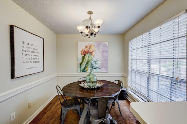 dining room featuring baseboards, wood finished floors, and a notable chandelier