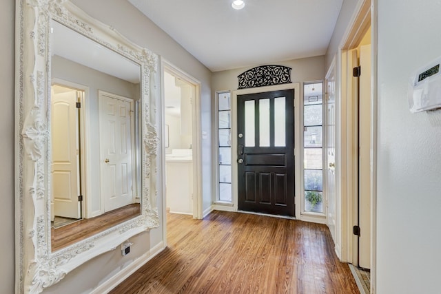 foyer entrance with baseboards and wood finished floors