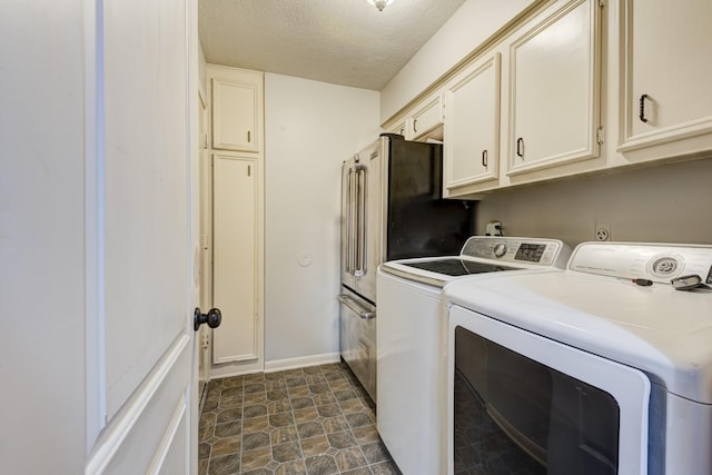 washroom with stone finish flooring, a textured ceiling, independent washer and dryer, cabinet space, and baseboards