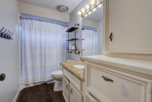 bathroom featuring toilet, wood finished floors, and vanity