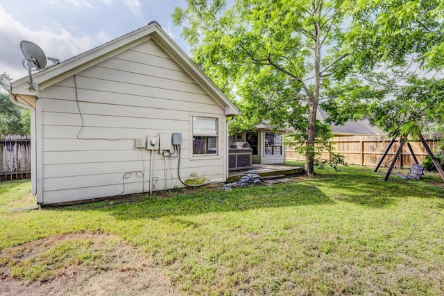 back of house with fence and a lawn