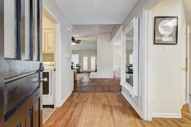 foyer with washer / clothes dryer, a ceiling fan, baseboards, and light wood-style floors