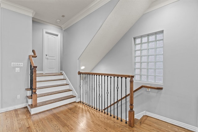 stairs with crown molding, baseboards, and wood finished floors