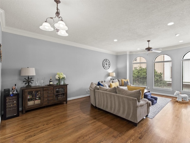 living area featuring ornamental molding, a textured ceiling, and wood finished floors