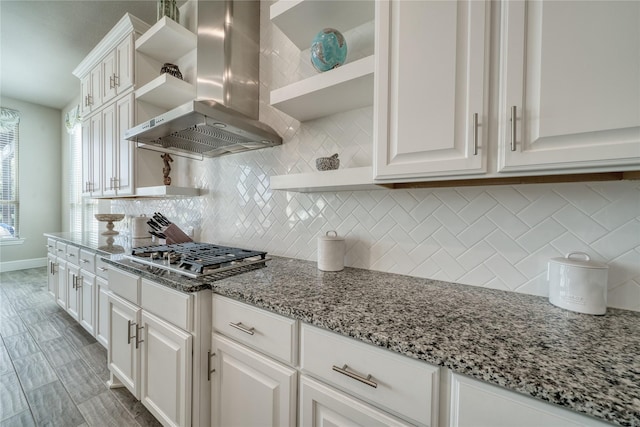 23935 Birchwood Lake Ln, Katy, TX 77493 - kitchen with wall chimney range hood, tasteful backsplash, open shelves, white cabinets, and stainless steel gas stovetop