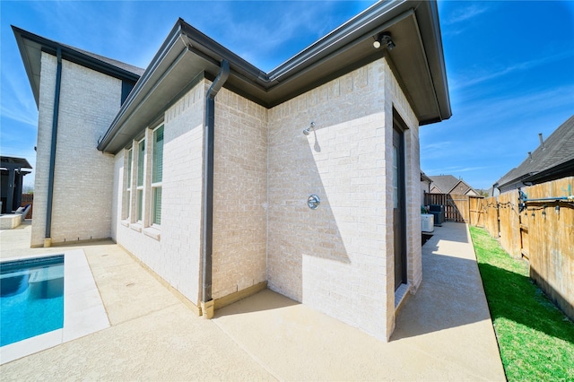 23935 Birchwood Lake Ln, Katy, TX 77493 - rear view of house featuring brick siding, a fenced backyard, and a patio area