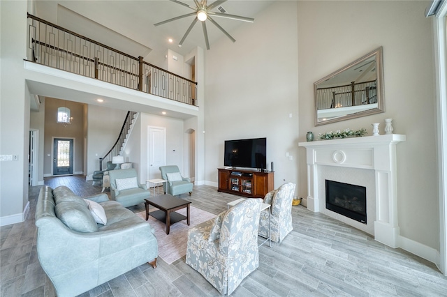 23935 Birchwood Lake Ln, Katy, TX 77493 - living room with baseboards, ceiling fan, wood finished floors, and a towering ceiling