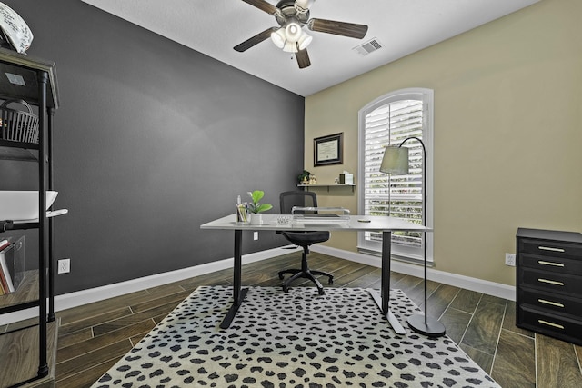 office featuring baseboards, ceiling fan, dark wood finished floors, and visible vents