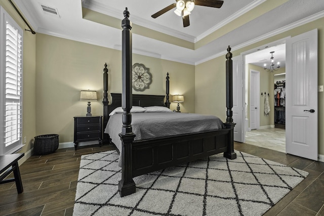 bedroom featuring a tray ceiling, multiple windows, and wood finished floors