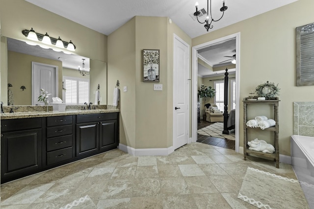 ensuite bathroom with double vanity, baseboards, a bath, ceiling fan with notable chandelier, and ensuite bath