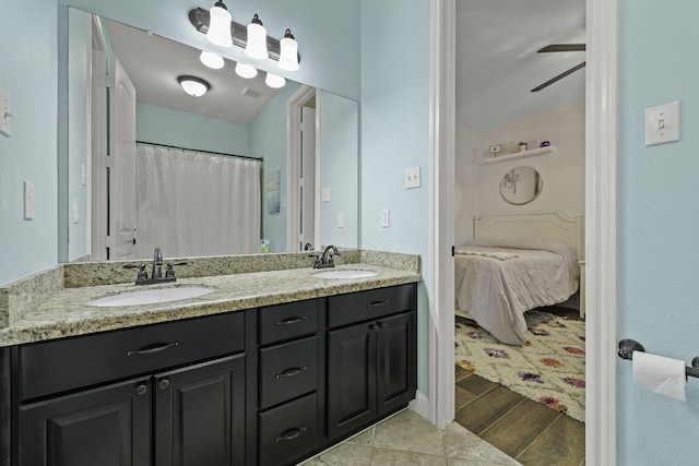 ensuite bathroom with double vanity, ceiling fan, a sink, and ensuite bath