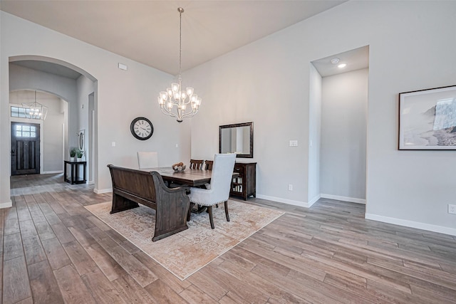 2502 Forest Side Ct, Missouri City, TX 77459 - dining area featuring arched walkways, a notable chandelier, baseboards, and wood finished floors
