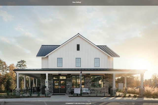 exterior space featuring french doors, a standing seam roof, a porch, and metal roof