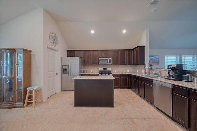 2903 Blue Mist Bnd, Brookshire, TX 77423 - kitchen with stainless steel appliances, a sink, dark brown cabinetry, light stone countertops, and a center island