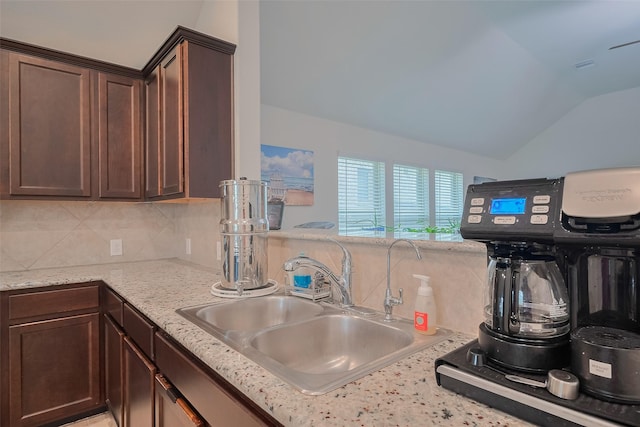 2903 Blue Mist Bnd, Brookshire, TX 77423 - kitchen featuring tasteful backsplash, a sink, dark brown cabinetry, lofted ceiling, and light stone counters