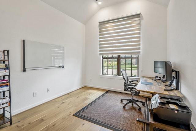 office with baseboards, vaulted ceiling, and wood finished floors