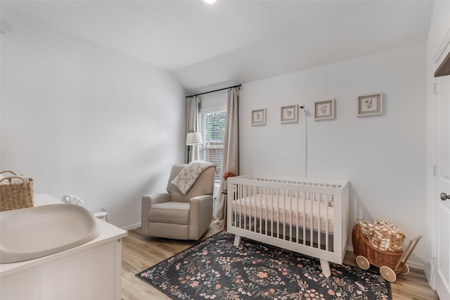 21623 Mount Frisell Ln, Porter, TX 77365 - bedroom featuring baseboards, vaulted ceiling, a crib, and light wood-style flooring