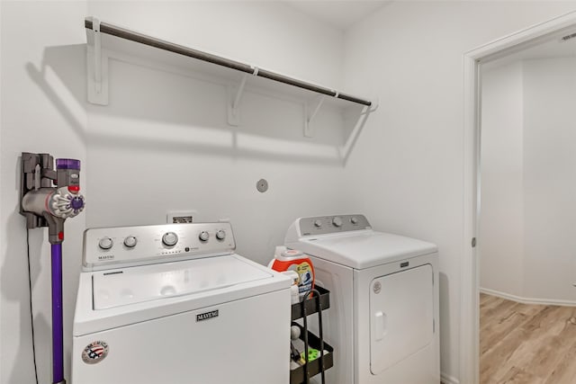 21623 Mount Frisell Ln, Porter, TX 77365 - clothes washing area with baseboards, laundry area, light wood finished floors, and independent washer and dryer