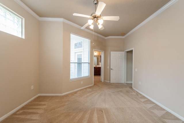 unfurnished room featuring crown molding, light colored carpet, and a wealth of natural light