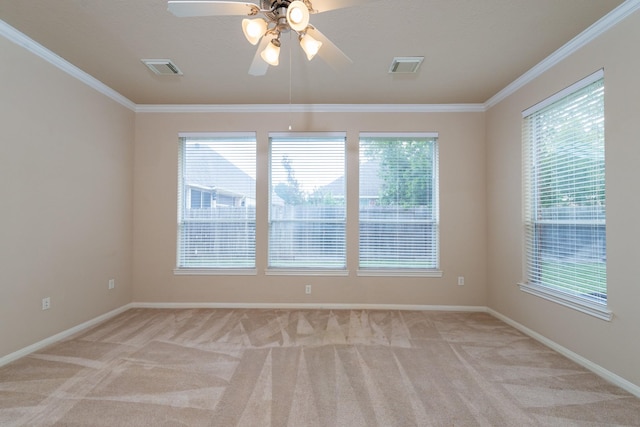 spare room featuring crown molding, a ceiling fan, and light colored carpet